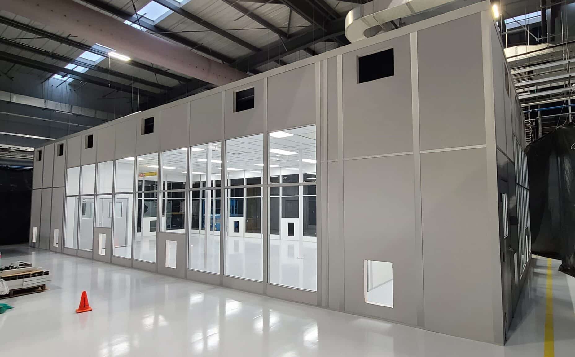 A tall walled modular enclosure within an existing warehouse.