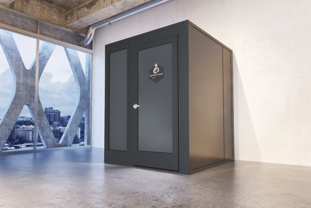 A sleek, modern lactation pod in an industrial office setting provides a private and comfortable space for nursing mothers.