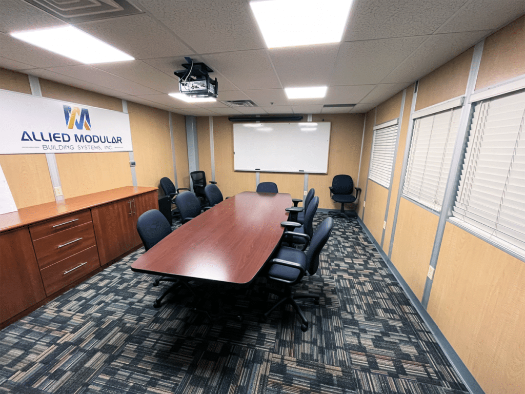 A modular meeting/conference room, with a wooden table in the middle.