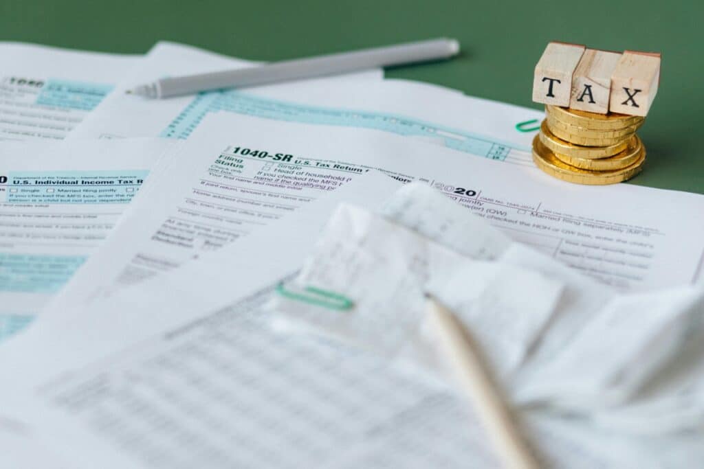 A table with tax forms and pens on it.