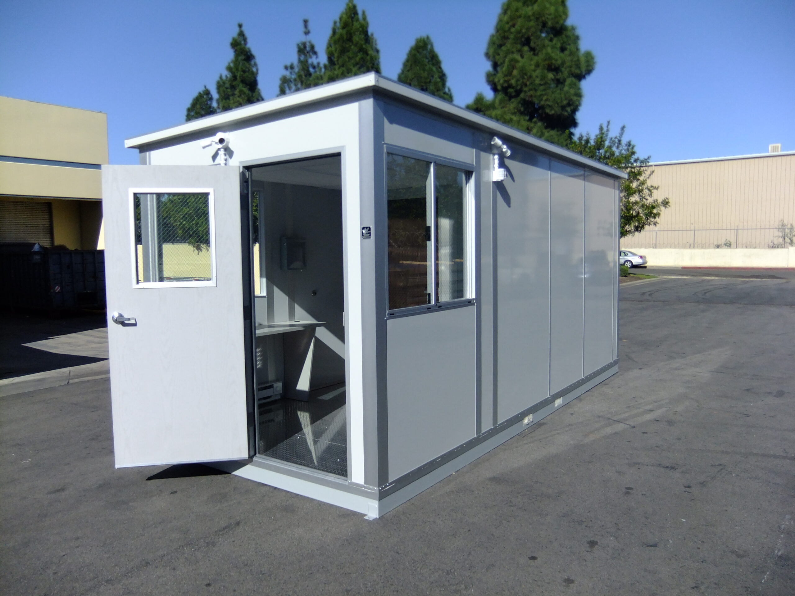 A compact modular shipping and receiving office with an open door and large windows, designed for efficient logistics operations.