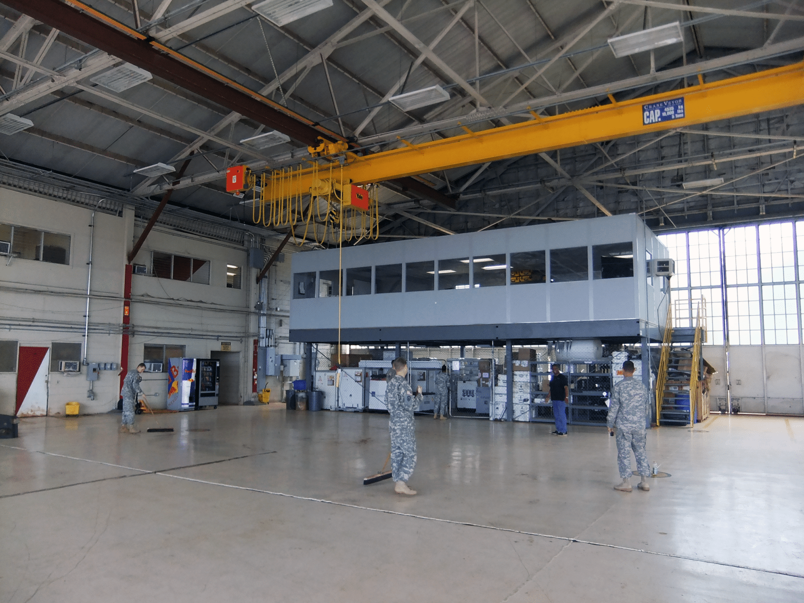 Allied Modular warehouse mezzanine with enclosed office space elevated above a production floor inside an industrial facility.