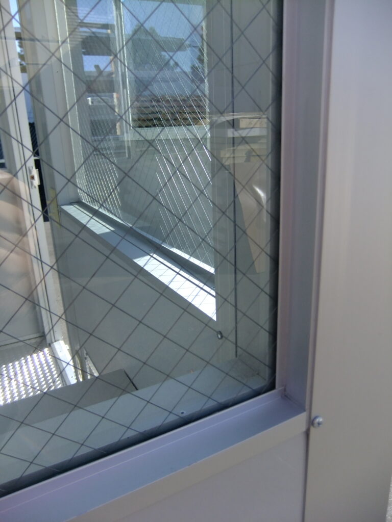 Close-up of wire-reinforced safety glass window on a custom guard shack.