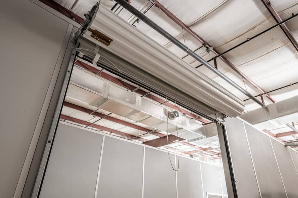 Close-up of a modular warehouse partition featuring a roll-up door mechanism, highlighting the customizable and functional design for dividing industrial spaces.